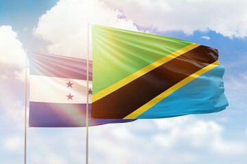 Sunny blue sky and flags of tanzania and honduras