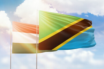 Sunny blue sky and flags of tanzania and hungary