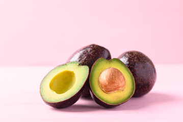 Ripe avocado fruit ready to eating on pink background