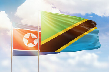 Sunny blue sky and flags of tanzania and north korea
