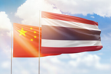 Sunny blue sky and flags of thailand and china
