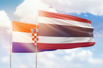 Sunny blue sky and flags of thailand and croatia