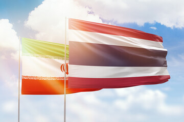 Sunny blue sky and flags of thailand and iran