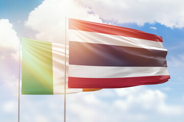 Sunny blue sky and flags of thailand and ireland