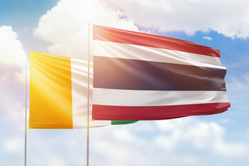 Sunny blue sky and flags of thailand and ivory coast