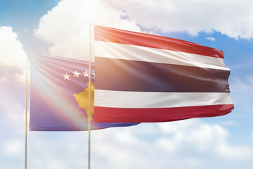 Sunny blue sky and flags of thailand and kosovo