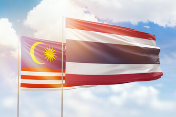 Sunny blue sky and flags of thailand and malaysia