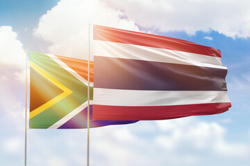 Sunny blue sky and flags of thailand and south africa