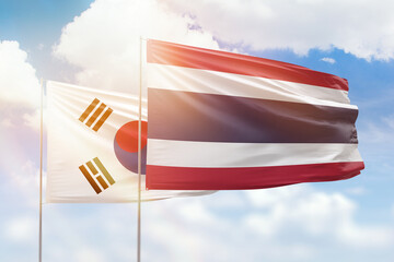 Sunny blue sky and flags of thailand and south korea