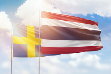 Sunny blue sky and flags of thailand and sweden