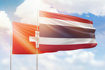 Sunny blue sky and flags of thailand and switzerland