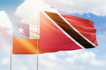Sunny blue sky and flags of trinidad and tobago and chile