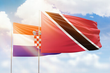 Sunny blue sky and flags of trinidad and tobago and croatia