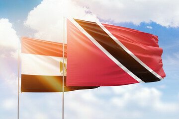 Sunny blue sky and flags of trinidad and tobago and egypt