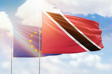 Sunny blue sky and flags of trinidad and tobago and european union