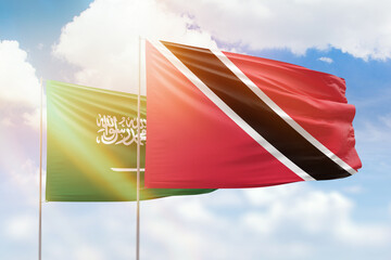 Sunny blue sky and flags of trinidad and tobago and saudi arabia
