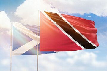 Sunny blue sky and flags of trinidad and tobago and scotland