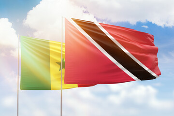 Sunny blue sky and flags of trinidad and tobago and senegal