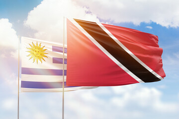 Sunny blue sky and flags of trinidad and tobago and uruguay
