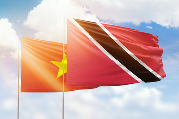 Sunny blue sky and flags of trinidad and tobago and vietnam