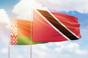 Sunny blue sky and flags of trinidad and tobago and belarus