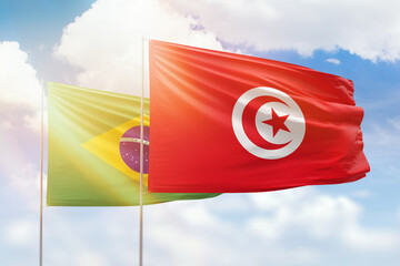 Sunny blue sky and flags of tunisia and brazil