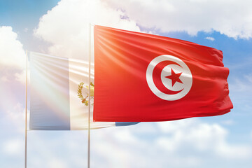 Sunny blue sky and flags of tunisia and guatemala