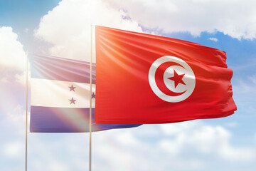 Sunny blue sky and flags of tunisia and honduras