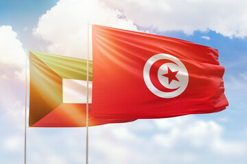 Sunny blue sky and flags of tunisia and kuwait