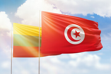 Sunny blue sky and flags of tunisia and lithuania