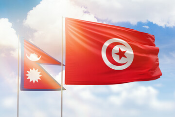 Sunny blue sky and flags of tunisia and nepal