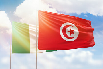 Sunny blue sky and flags of tunisia and nigeria