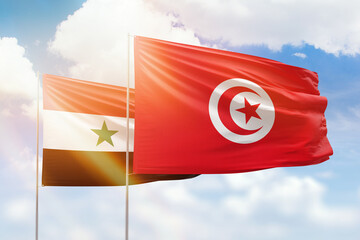 Sunny blue sky and flags of tunisia and syria