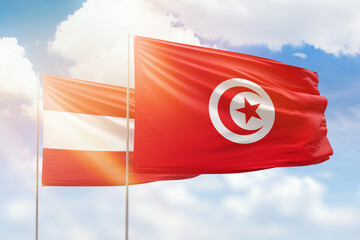 Sunny blue sky and flags of tunisia and austria