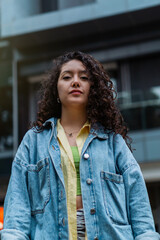 Portrait of a young woman with curly hair looking at the camera.