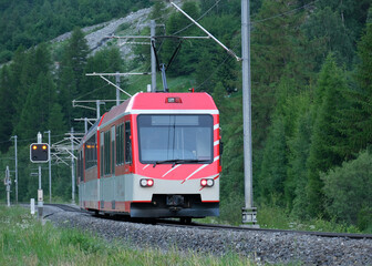 Selective focus picture with motion blur and noise effect of red train at the railway from Zermatt.