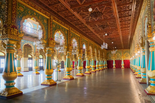 Mysore, Karnataka, India - November 25th 2018 : Beautiful decoated interior ceiling and pillars of the Ambavilasa Hall, inside the royal Mysore Palace. Gold used on gilded columns and glass ceiling.