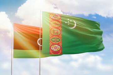 Sunny blue sky and flags of turkmenistan and libya
