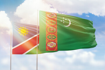 Sunny blue sky and flags of turkmenistan and namibia