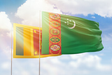 Sunny blue sky and flags of turkmenistan and sri lanka