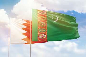 Sunny blue sky and flags of turkmenistan and bahrain
