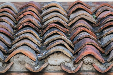 Old rooftop background - typical European architecture texture. Orange tiles covered with lichen.