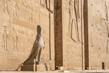 Sculpture of a falcon in a crown on the background of the wall of the temple of Horus in Edfu....