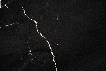 Crumpled black paper with a detailed texture. Close up the paper with white cracks. Rough paper...
