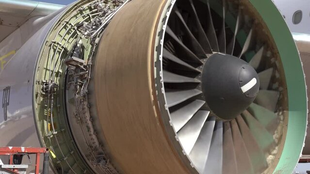 Commercial airplane turbine engine fan blades spinning while under maintenance.