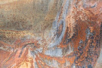 Close-up of a galvanized steel sheet. Picturesque rusty stains and pockets of corrosion are visible on the surface. Background. Abstraction.