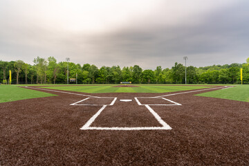 View of  high school synthetic turf baseball field looking from batters box toward the outfield. - obrazy, fototapety, plakaty