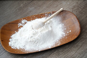 Wooden spoon with flour on the countertop in the kitchen.