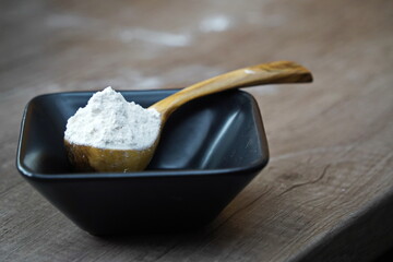 Wooden spoon with flour on the countertop in the kitchen.