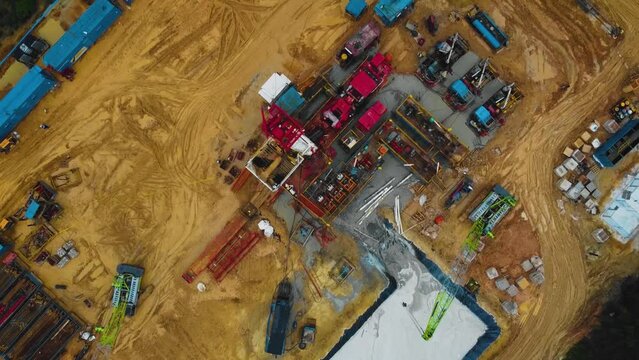 Cinematic Drone Shot of Onshore Drilling and Workover Rig structure and Rig equipment for oil exploration and exploitation in the middle of jungle surrounded by palm oil trees during sunset time.
